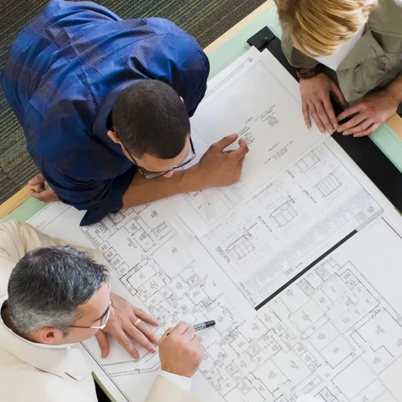 Team reviewing large-format architectural plans; AEC application photo.
