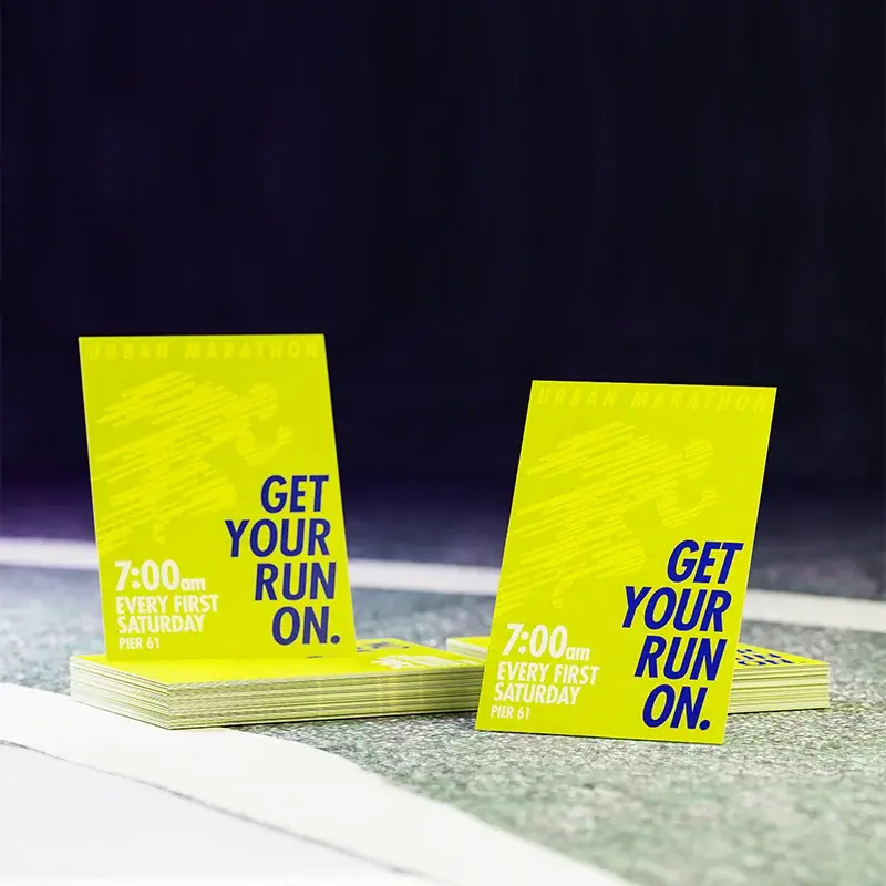 Stacks of neon-yellow GET YOUR RUN ON promotional print samples in different sizes
