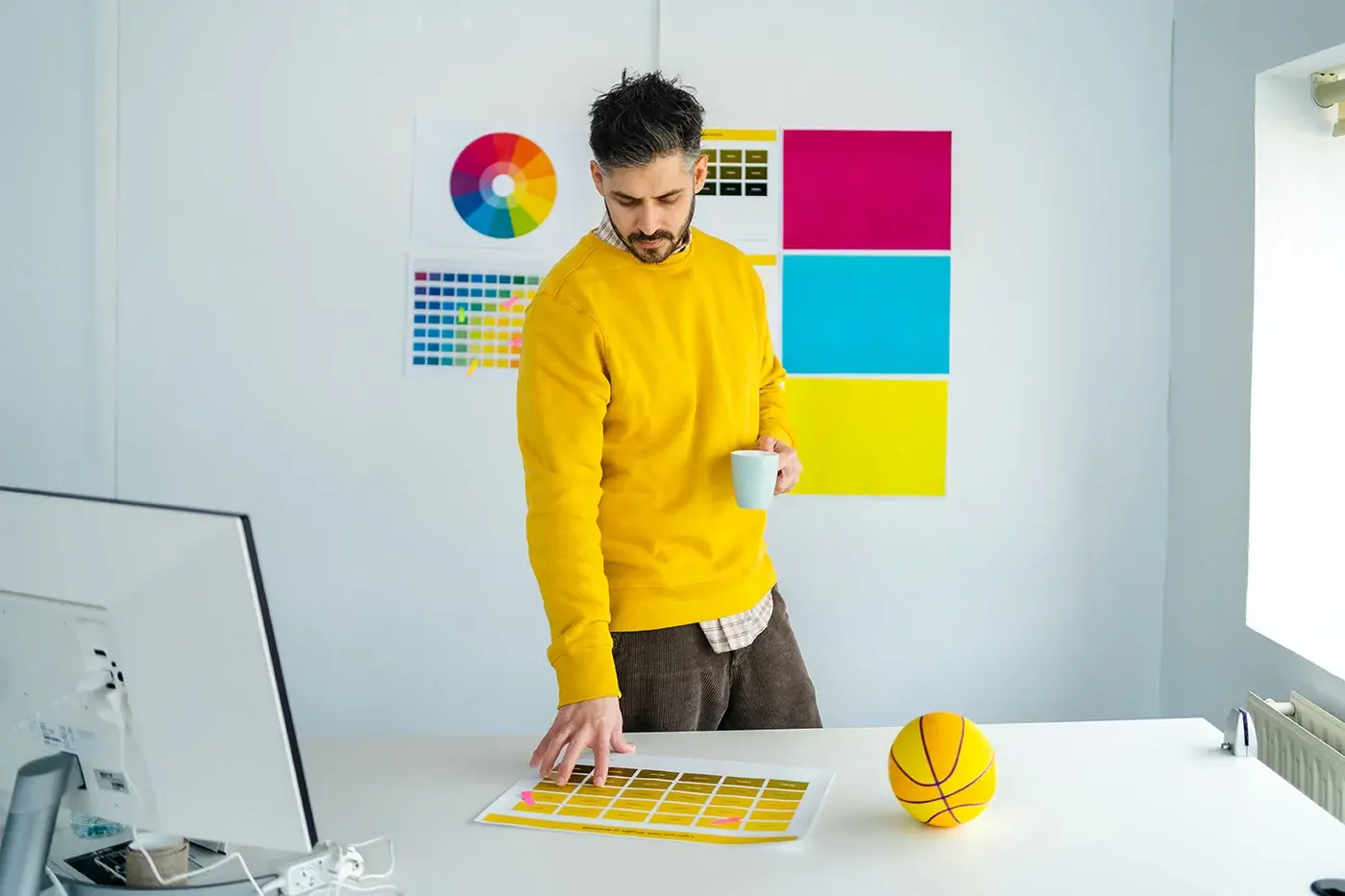 Designer comparing printed samples against colour reference chart