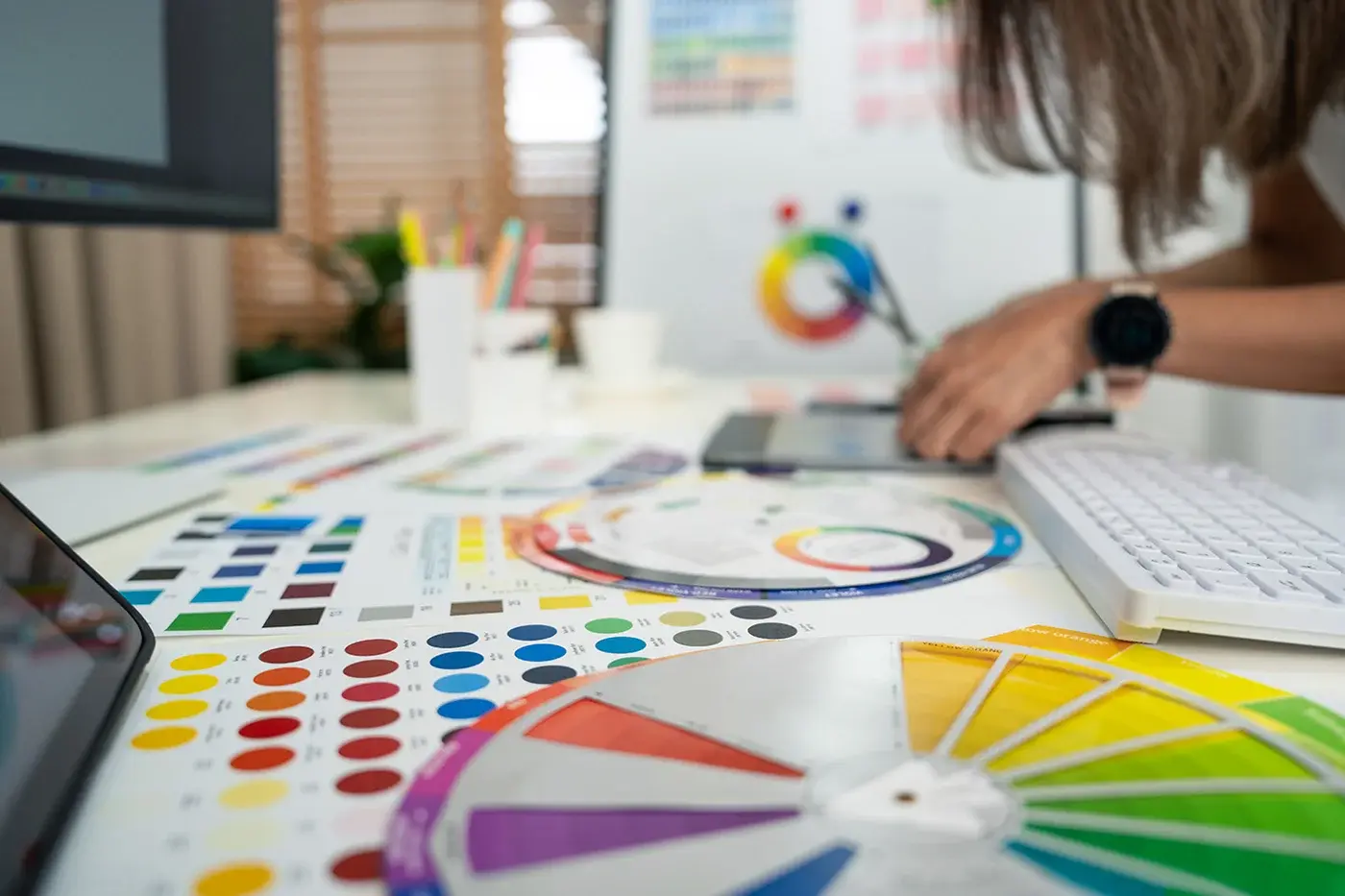 Person evaluating printed colour swatches at a desk