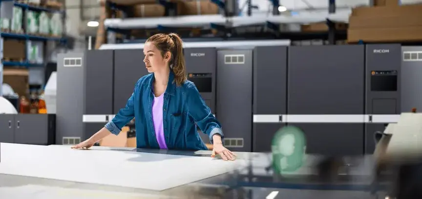 Operator beside Ricoh production print equipment